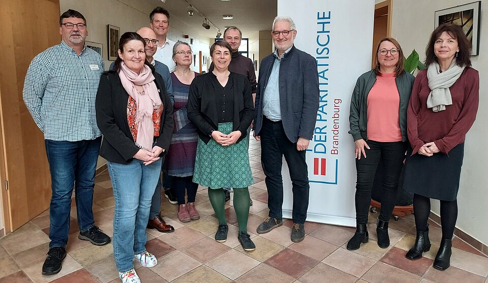 Gruppenfoto neben Banner Der Paritätische