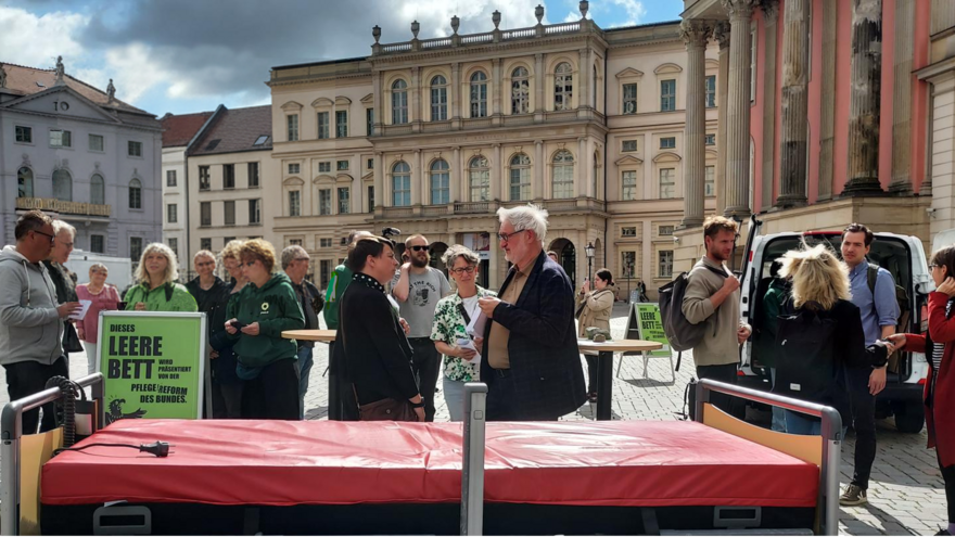 Protestaktion mit Klinikbett auf Platz