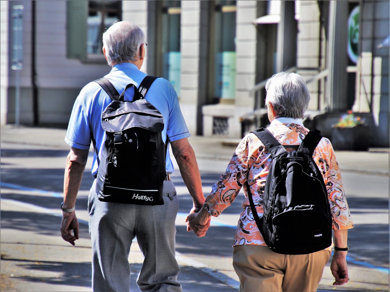 zwei ältere Menschen gehen Hand in Hand